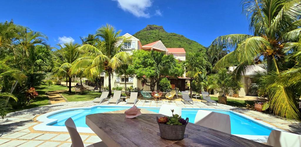een villa met een zwembad en een huis bij Lakaz Del Sol - NEWLY RENOVATED modern and elegant apartments with luxurious garden, pool, barbecue and bar area in Tamarin