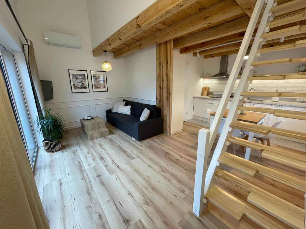 a living room with a black couch and a staircase at Cozy House in Świnoujście