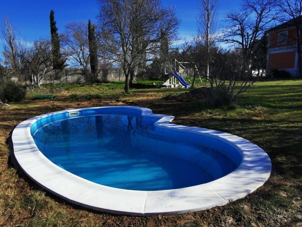 una gran piscina azul en un patio en La Casa Grande de Gormaz en Quintanas de Gormaz