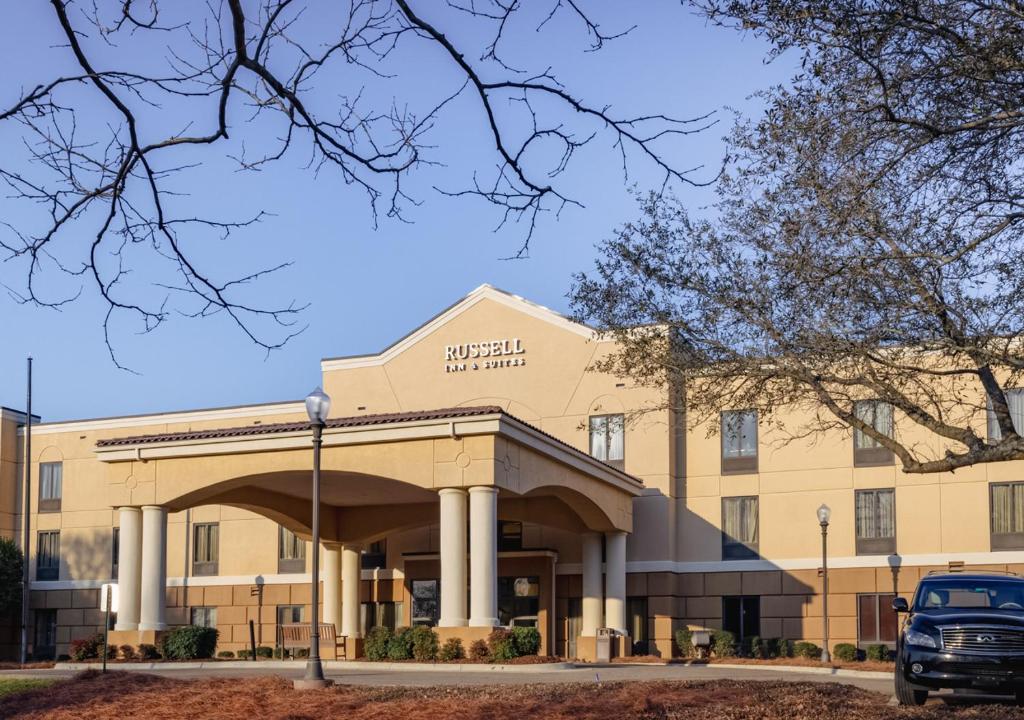un edificio con un coche aparcado delante en Russell Inn and Suites, en Starkville