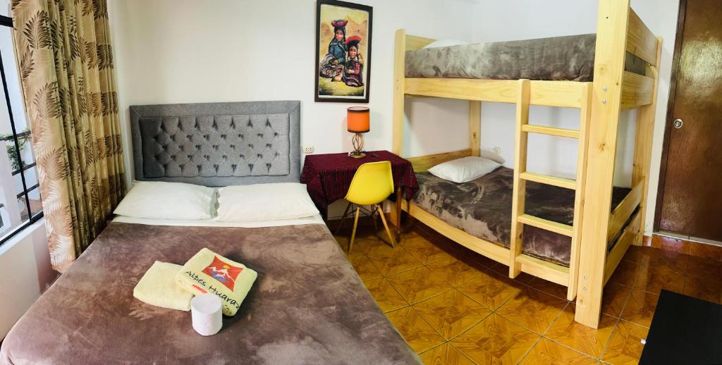 a bedroom with two bunk beds and a desk at Alpes Huaraz in Huaraz