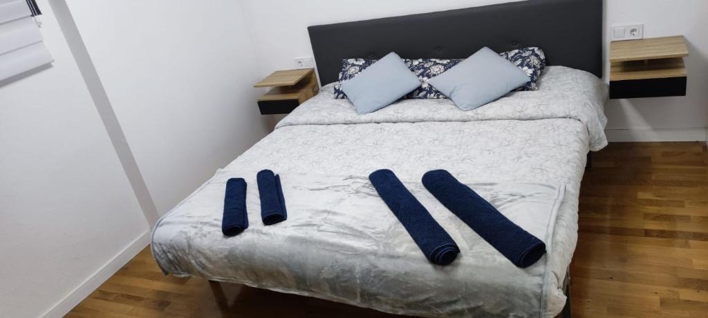 1 dormitorio con 1 cama con zapatillas azules en Estudio completo familiar, en La Jonquera