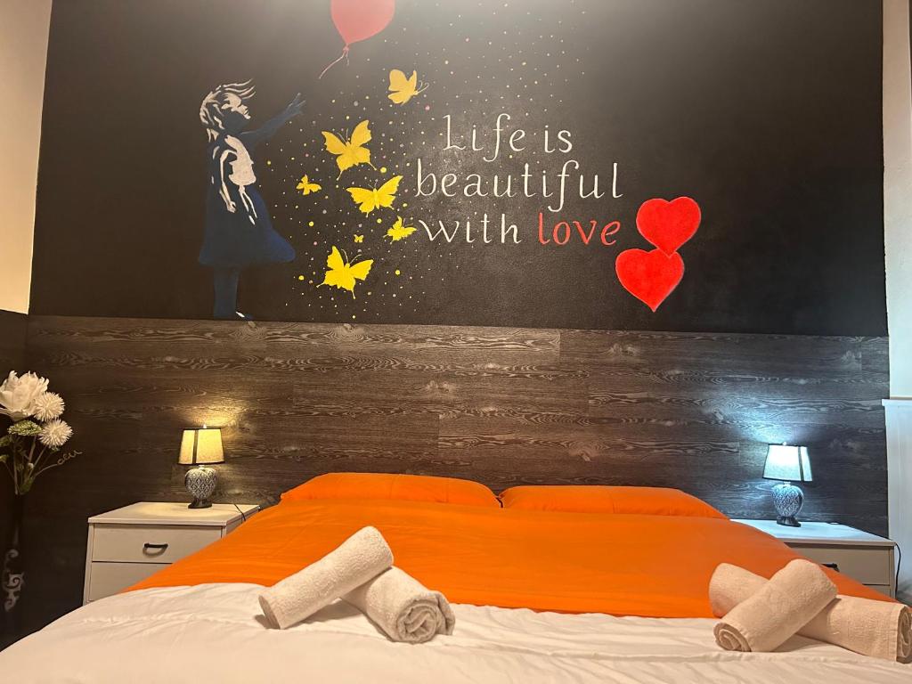 een slaapkamer met een bed met oranje lakens en een muur bij House of artist in Isolabona