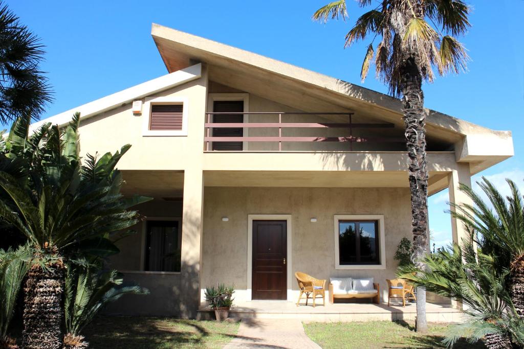 uma casa com uma palmeira em frente em Villa Sam em Comiso