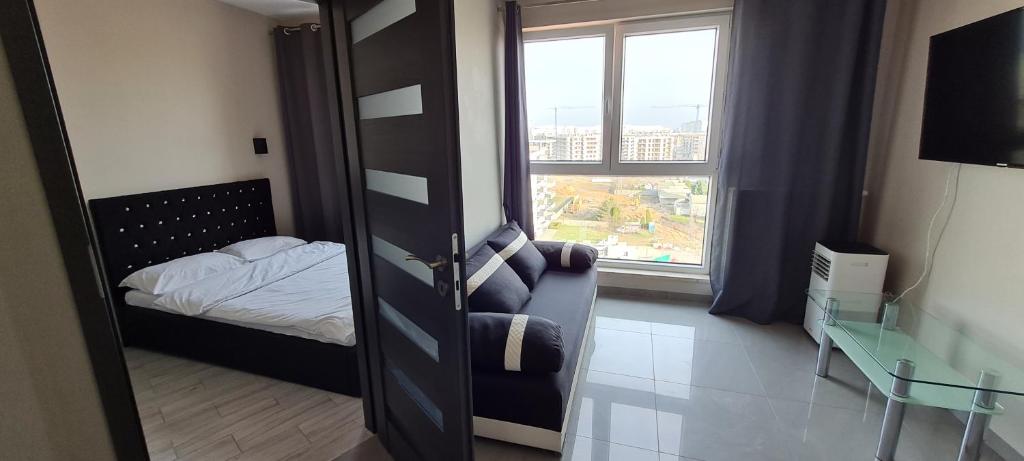 a small bedroom with a bed and a window at Metro Modern Warsaw Apartments in Warsaw