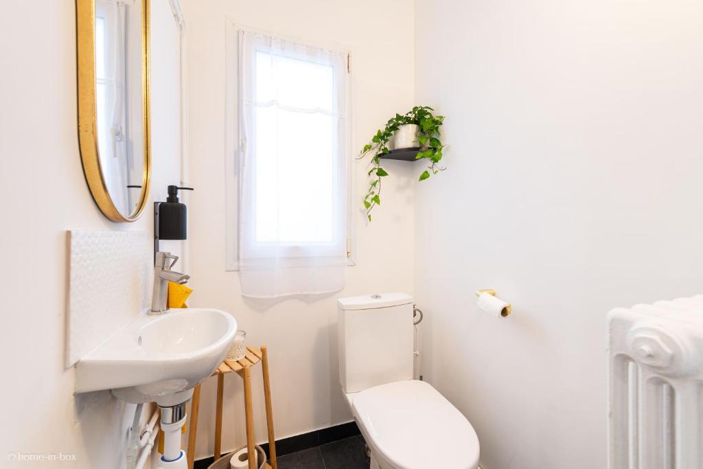 a white bathroom with a toilet and a sink at Nid douillet entre Paris et Disney in Vaires-sur-Marne