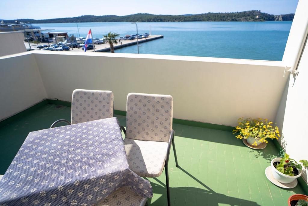 a balcony with two chairs and a view of the water at Pension More in Šibenik