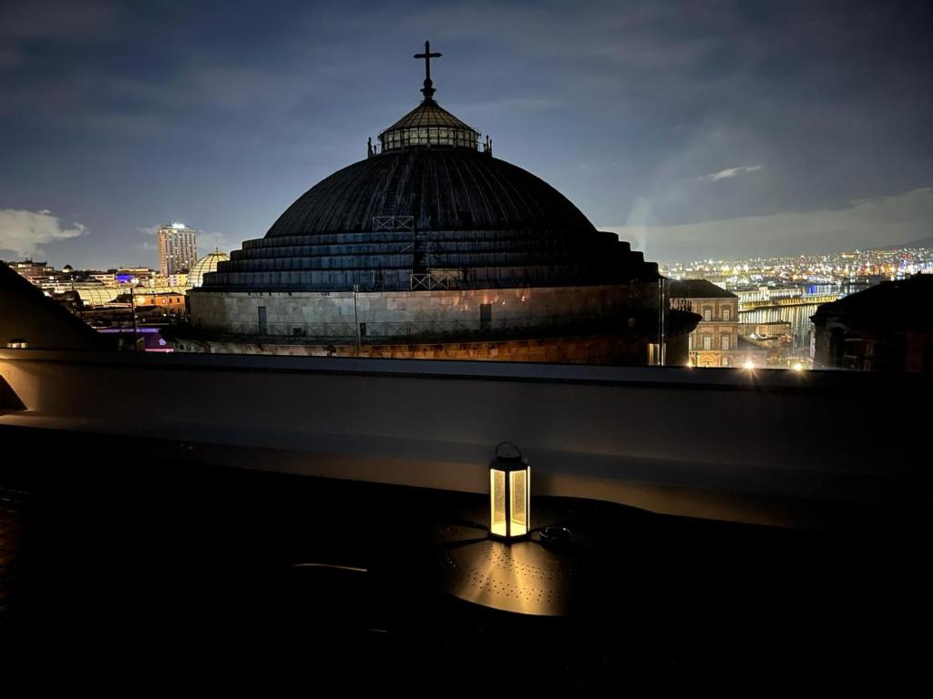 a building with a cross on top of it at night at Lucullo's Rooftop in Naples