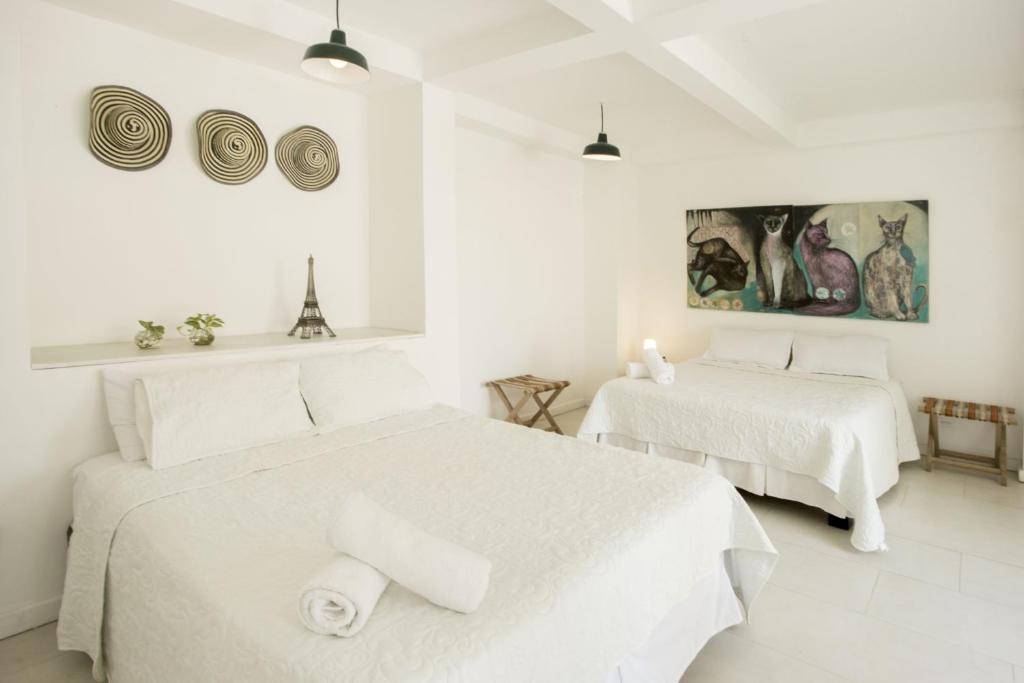 Duas camas num quarto branco com paredes brancas em Hotel Barahona Cartagena em Cartagena das Índias