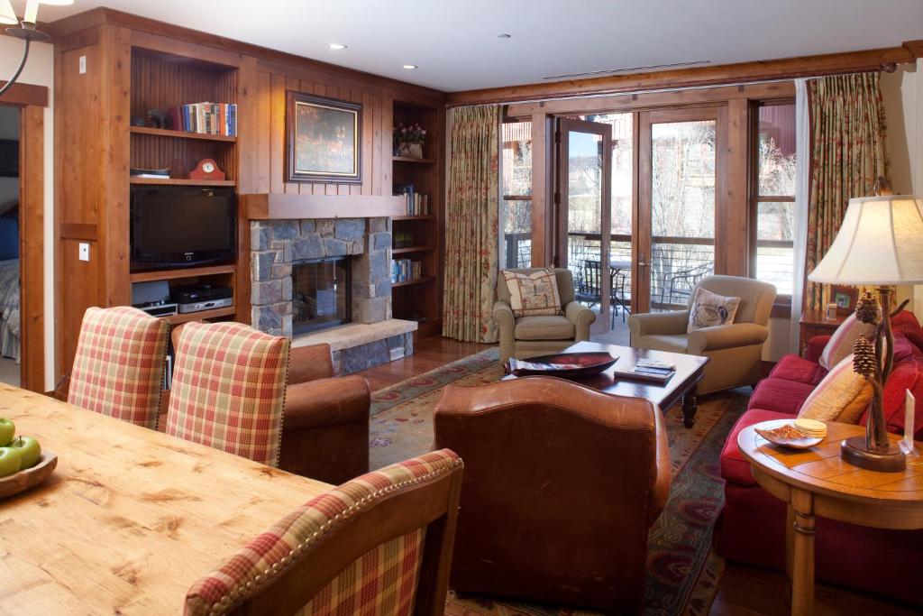 a living room with a table and a fireplace at Countryside at Snowmass - CoralTree Residence Collection in Snowmass Village