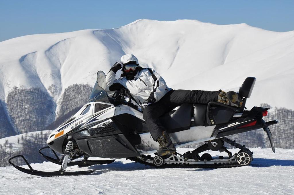 PilipetsにあるGoryanynの雪上のスノーモービルに座る男