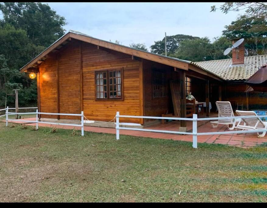uma casa de madeira com uma cerca branca em frente em Terrinha Nosso Paraíso em São Carlos