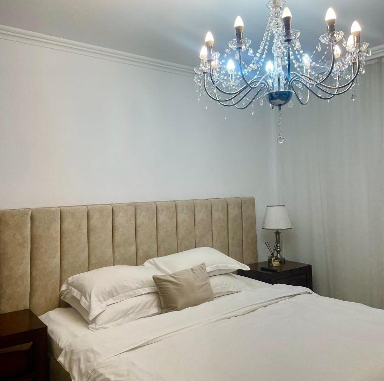- une chambre avec un grand lit et un lustre dans l'établissement Duke’s House, à Bistriţa