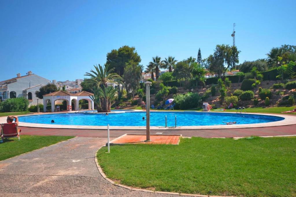 ein großer Pool in einem Park mit einem Haus in der Unterkunft Apartment in Santa Pola with parking space in Santa Pola