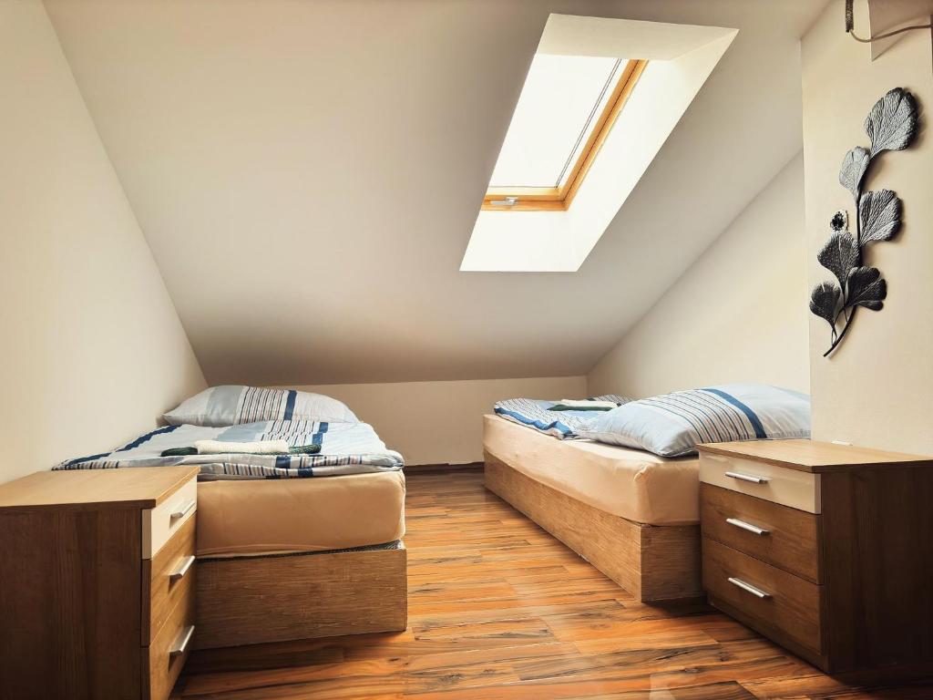 two beds in a attic bedroom with a window at R&S Apartment in Graz