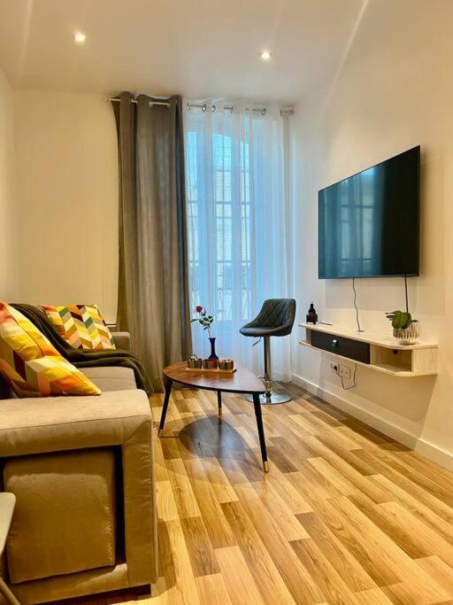 un salon avec un canapé et une télévision à écran plat dans l'établissement Dezy’s House, à Nice