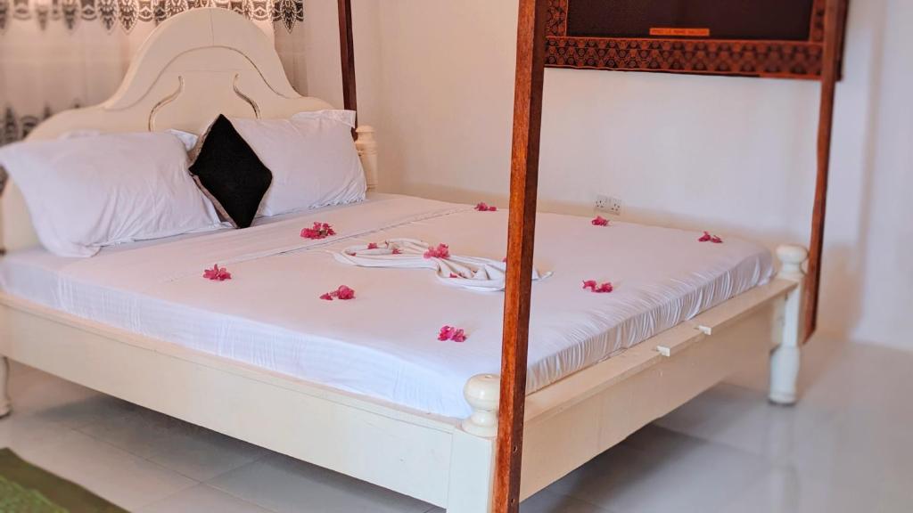 una camera con letto a castello e fiori rosa di Zanz bed and breakfast a Nungwi