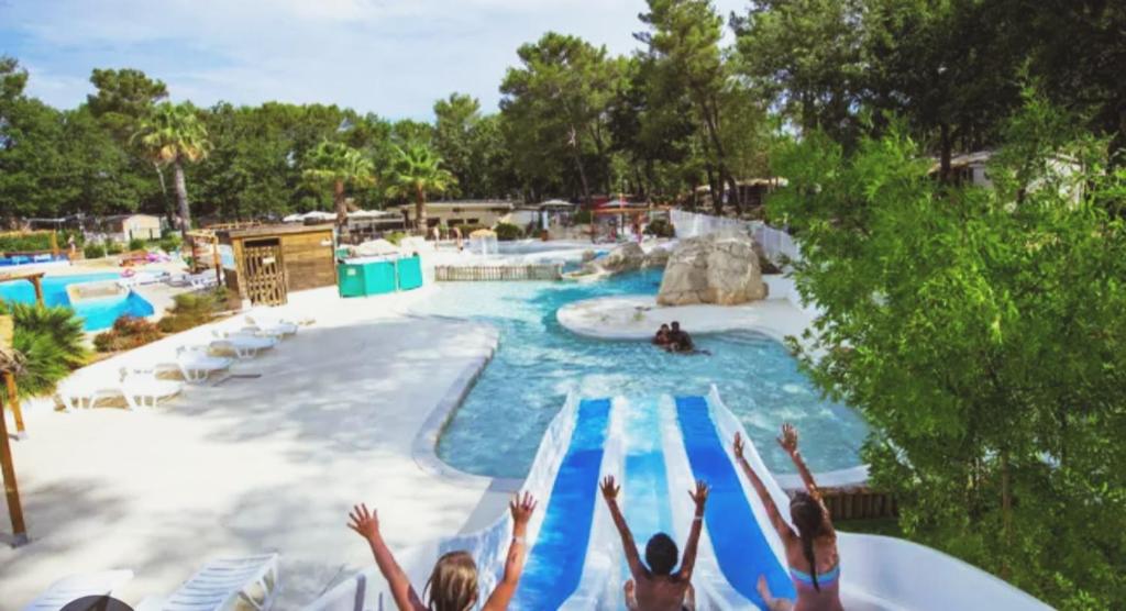 eine Gruppe von Menschen, die in einem Wasserpark in einen Pool springen in der Unterkunft Terre de Provence, mobil home camping 4* in Nans-les-Pins