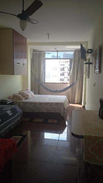 sypialnia z łóżkiem i dużym oknem w obiekcie Boulevard center w mieście Guarujá