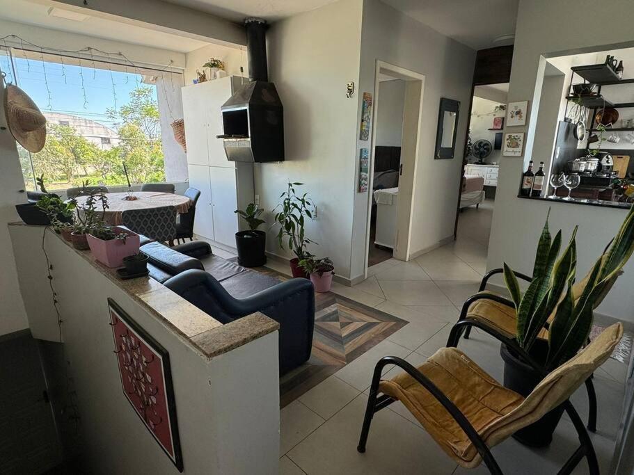 a living room with a kitchen and a living room with plants at De boa na Lagoa. in São Lourenço do Sul