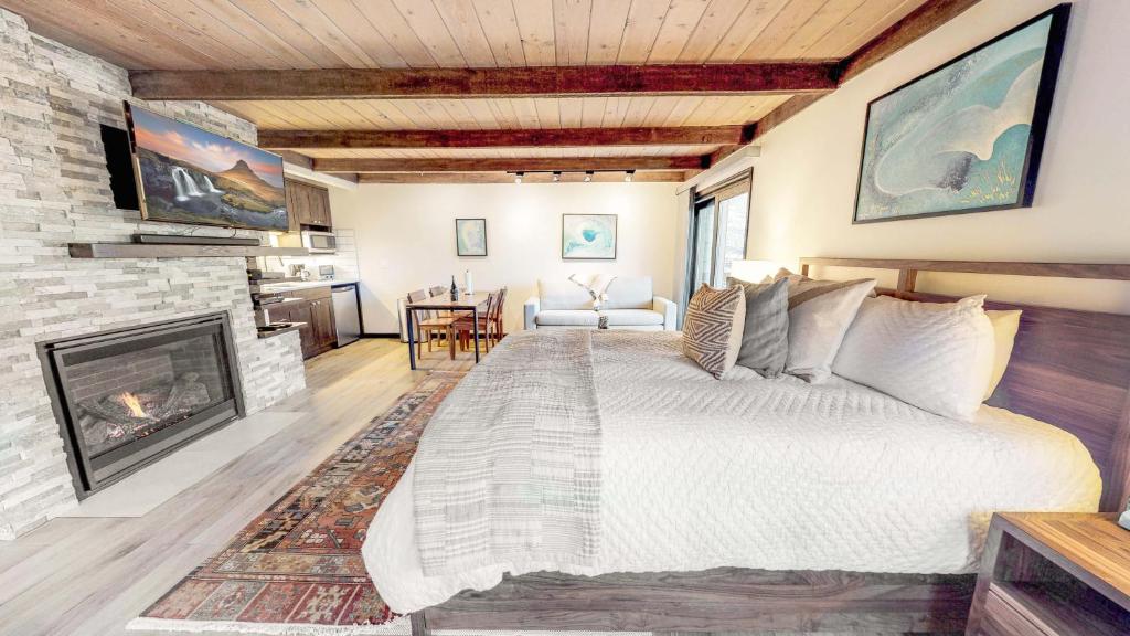 1 dormitorio con 1 cama grande y chimenea en Willows - CoralTree Residence Collection en Snowmass Village