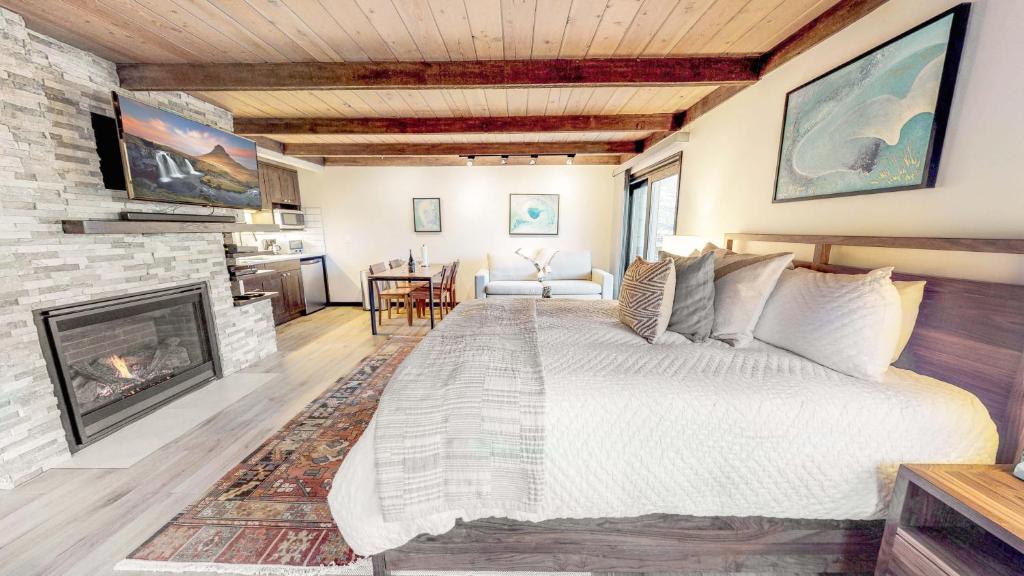Hotel 300 Carriage Way, a bedroom with a large bed and a fireplace at 300 Carriage Way in Snowmass Village