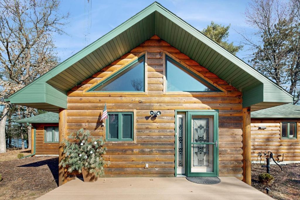 uma pequena cabana de madeira com um telhado verde em Log Cabin Life em Arkdale