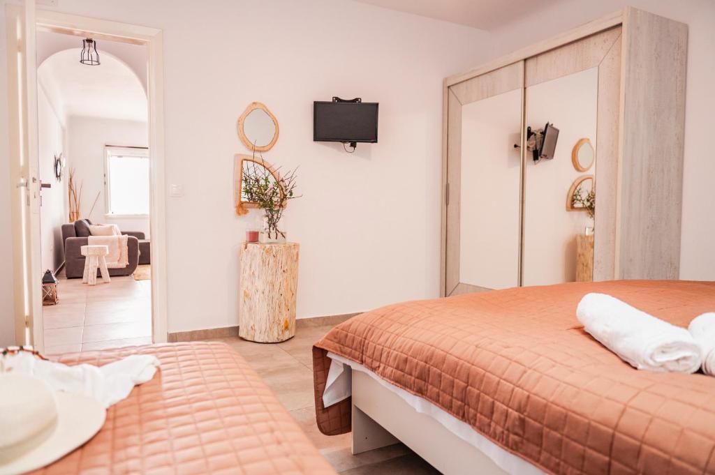 a bedroom with a bed and a living room at sunlight ornos suites, private hot tub in Mikonos