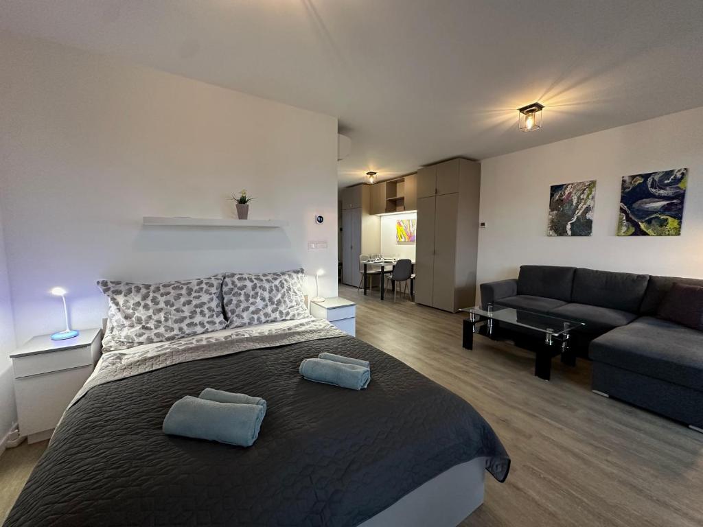 a bedroom with a large bed and a living room at Scamard Apartman in Zamárdi