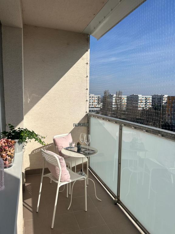 a balcony with a table and chairs on a building at Magnolia Studio Apartment in Trnávka