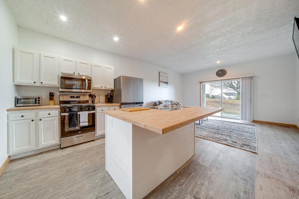 エリーにある4 Mi to Lake Golf-View Erie Condo with Porchの白いキャビネットと木製のカウンタートップを備えたキッチン