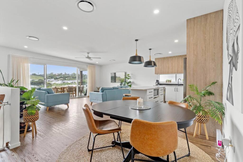 a kitchen and living room with a table and chairs at Valley Way in Lennox Head