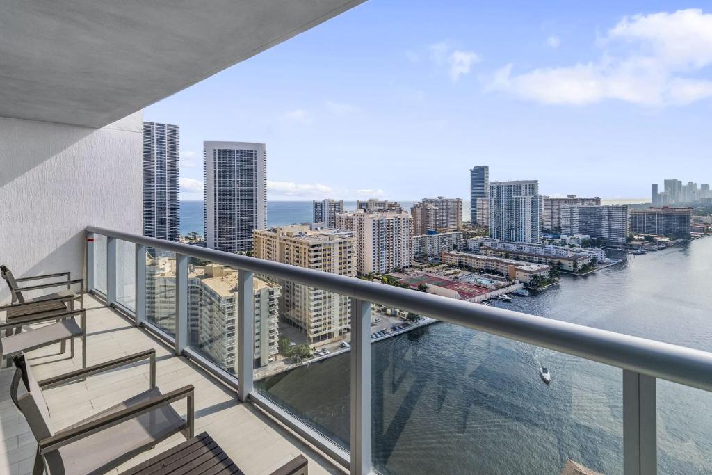 a balcony with two chairs and a view of the water at Spectacular Balcony View Retreat Resort Amenities in Hallandale Beach