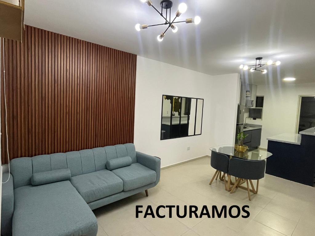 Casa V25 في كيريتارو: غرفة معيشة مع أريكة زرقاء وطاولة