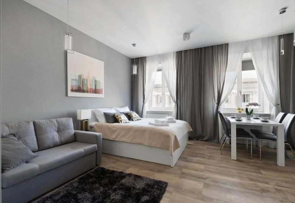 1 dormitorio con cama, mesa y sofá en Nowy Świat 60 - 170 m do metra - Prywatne mieszkanie w centrum Warszawy - Better Rental, en Varsovia