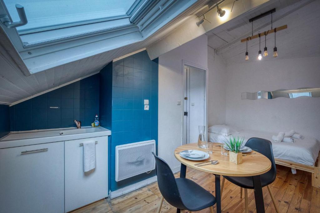 una cucina e una sala da pranzo con tavolo e sedie di Le Jean Jaurès - Gare de Grenoble / Calme a Fontaine