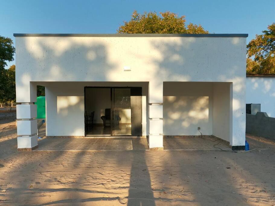 un edificio blanco con dos puertas abiertas. en A nice bungalow in Sexaxa., en Mirapene