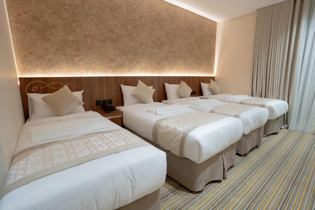 Postel nebo postele na pokoji v ubytování Rawha Al Maqam Ajyad Hotel