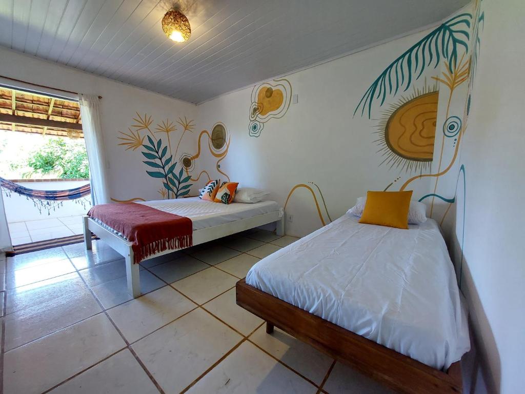 a bedroom with two beds and a window at Espaço Circular in Itacaré