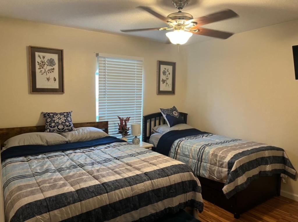 1 dormitorio con 2 camas y ventilador de techo en Guest House In Cantonment, en Jacksonville