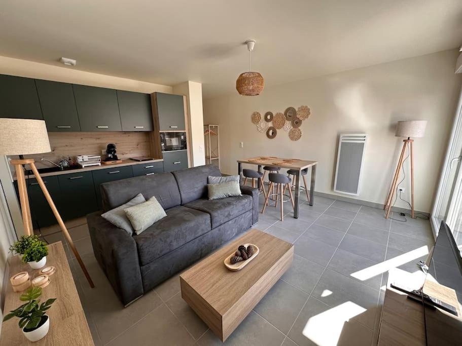 a living room with a couch and a table at A 600m de la plage - Le Nature - in Mimizan