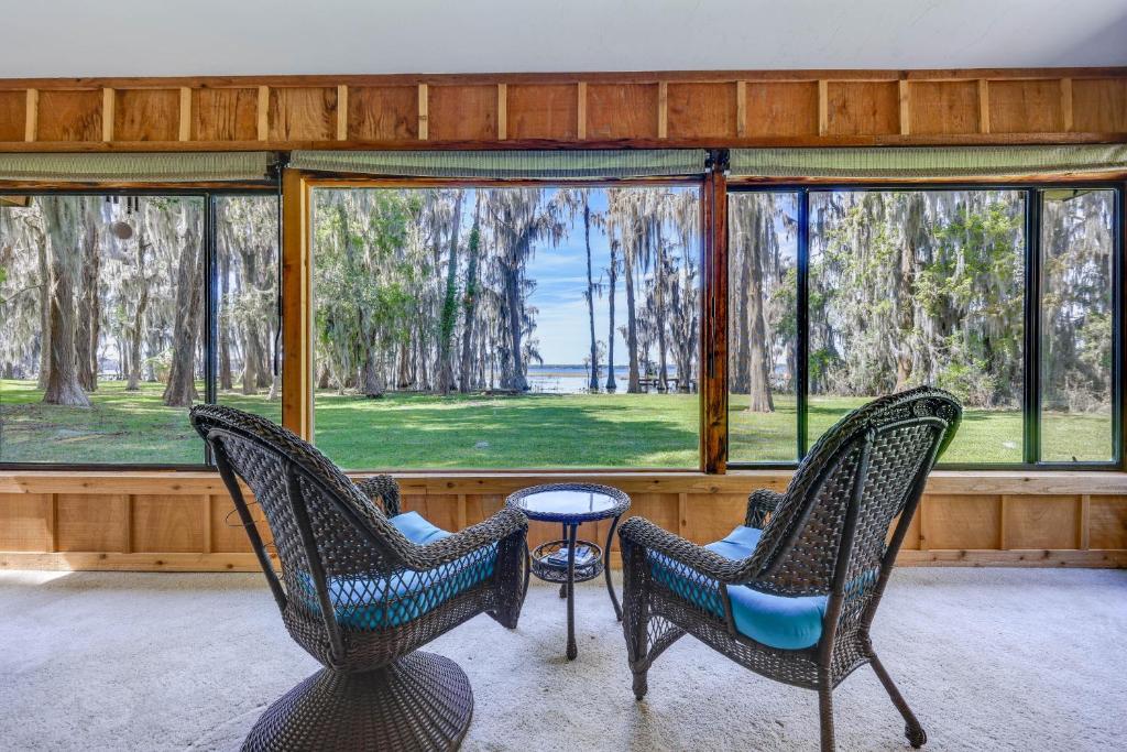 dwa krzesła i stół w pokoju z oknami w obiekcie Unique Melrose Home with Private Dock and Lake Access! w mieście Keystone Heights