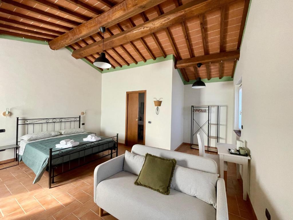 sala de estar con cama y sofá en Casale dell'Assiolo - Affittacamere, en Castiglione del Lago