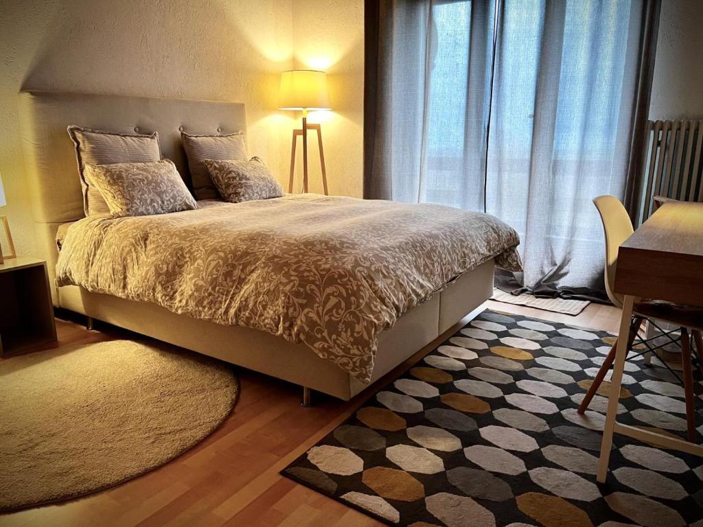 a bedroom with a large bed with a desk and a window at La Croisée des Chemins 