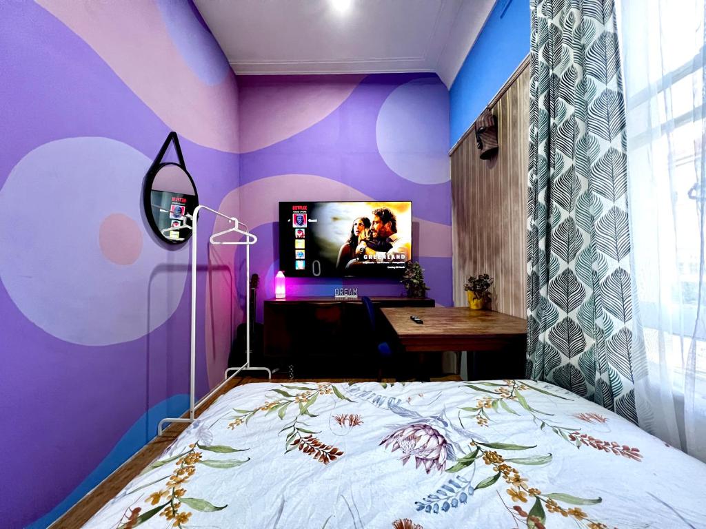 a bedroom with a purple wall with a bed and a desk at Zion in Sydney