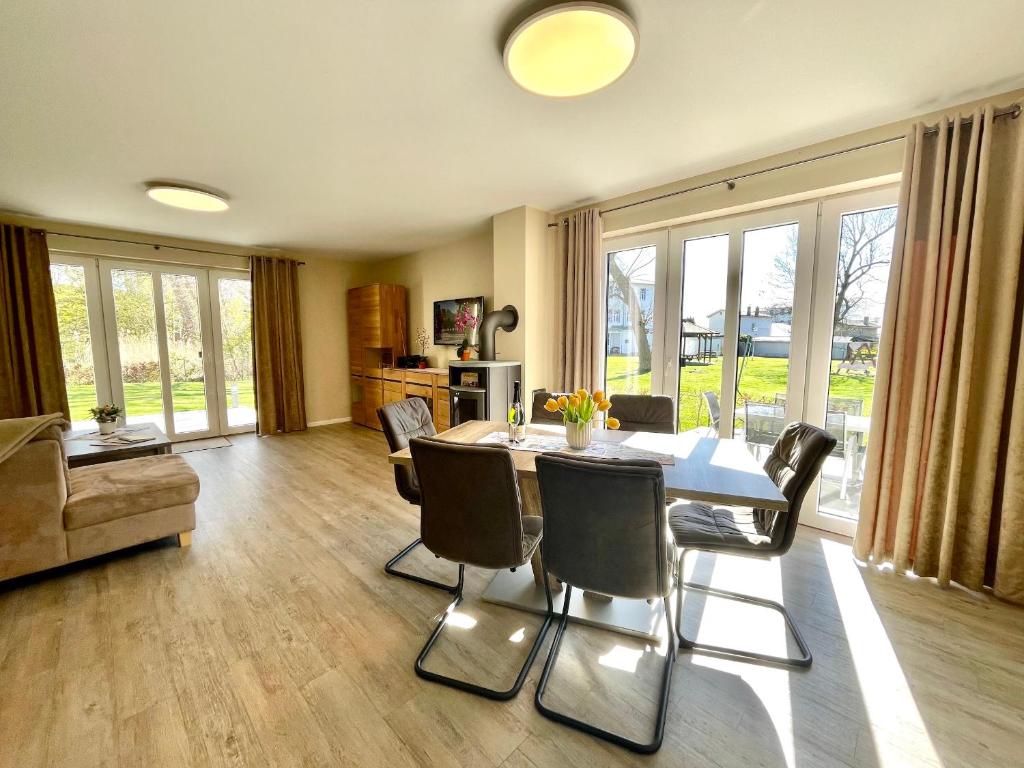 a living room with a dining room table and chairs at Haus Sterntaucher Appartement 4 in Thiessow