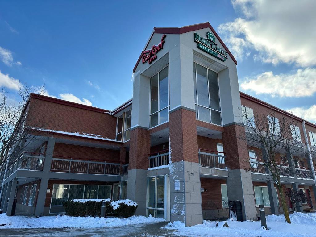 un edificio con un cartel en la nieve en Red Roof Inn Auburn Hills, en Auburn Hills