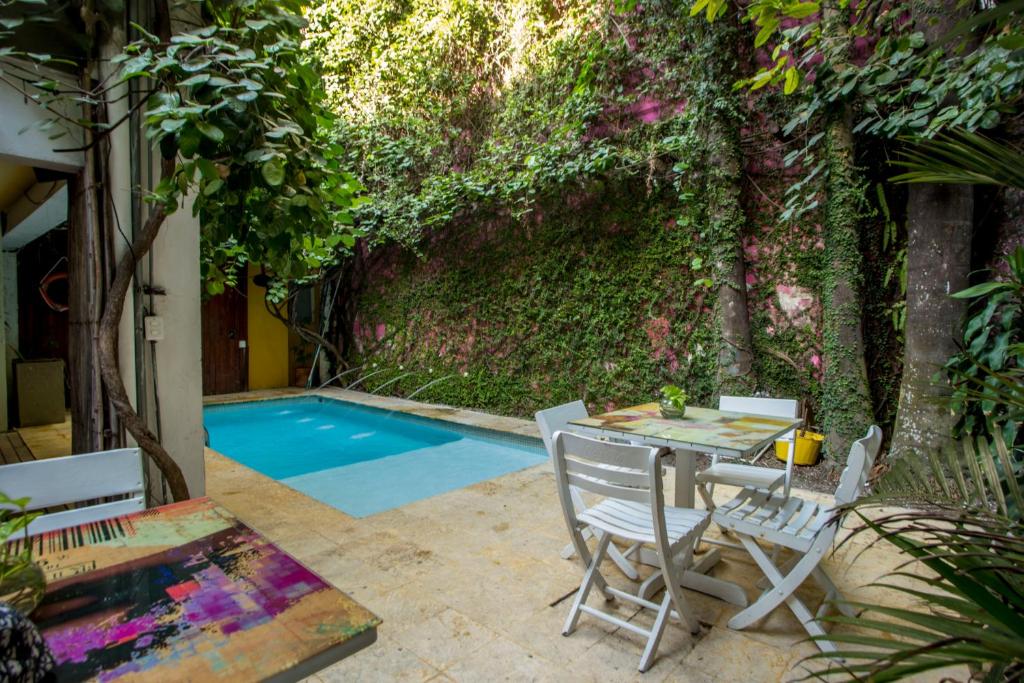 een patio met een tafel en stoelen naast een zwembad bij Hotel Barahona Cartagena in Cartagena