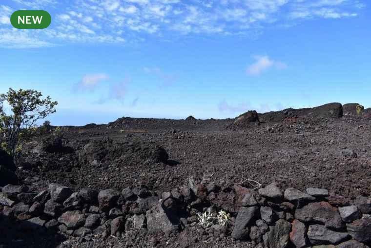 a field with rocks and a hill with a blue sky at Bring Your Camp in Hawaiian Ocean View