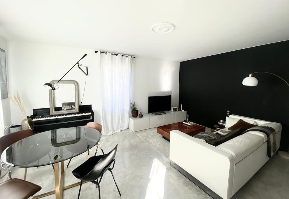 un salon avec un canapé et une table en verre dans l'établissement Appartement au pied du Stade de France, à Saint-Denis